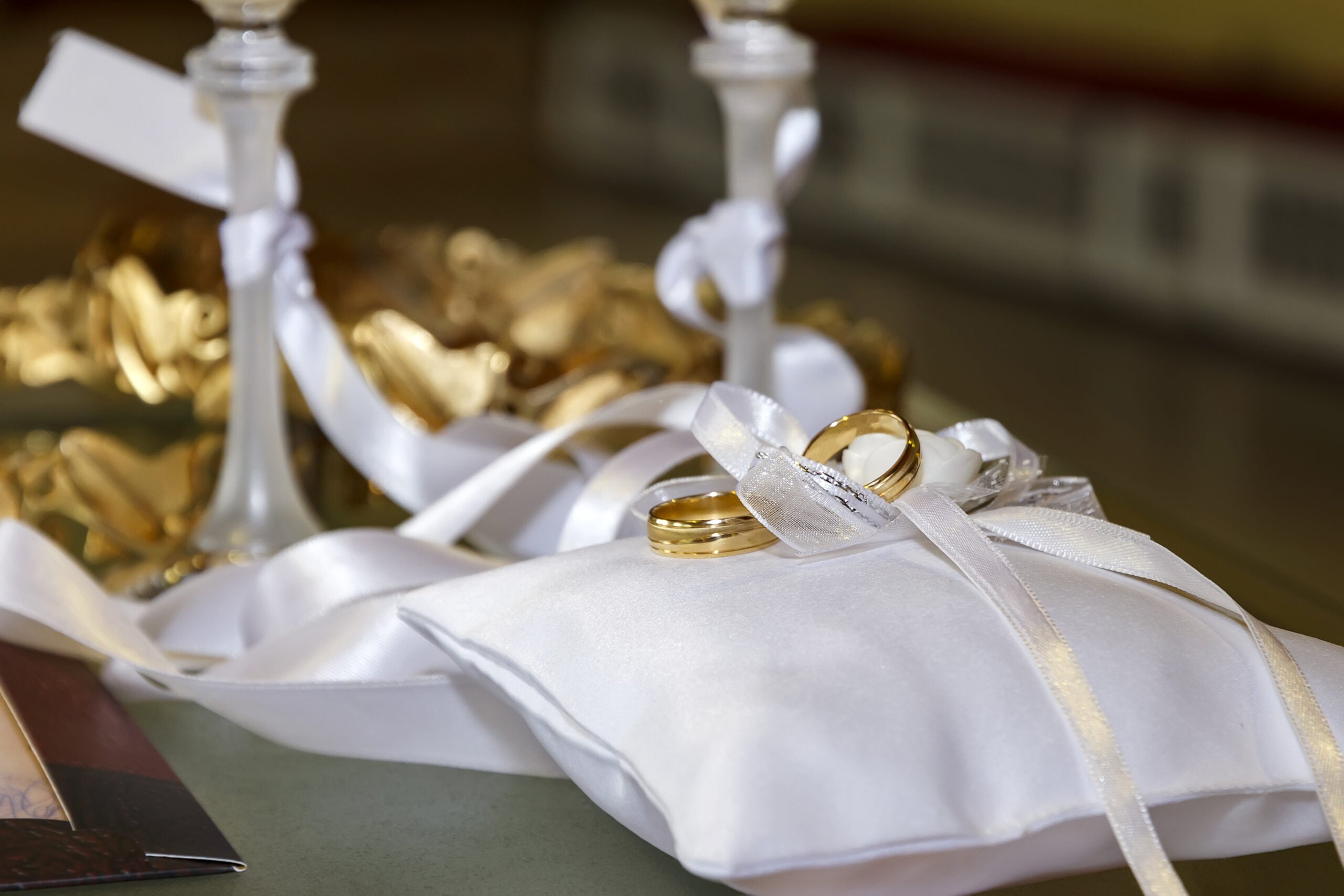 Weddings symbols, attributes. Wedding rings on the luxury white pillows. Selective focus